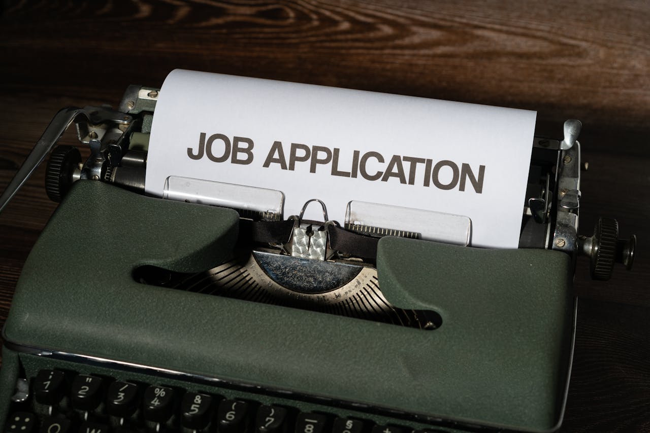 who-we-are-img Close-up of a vintage typewriter with a job application paper inserted.