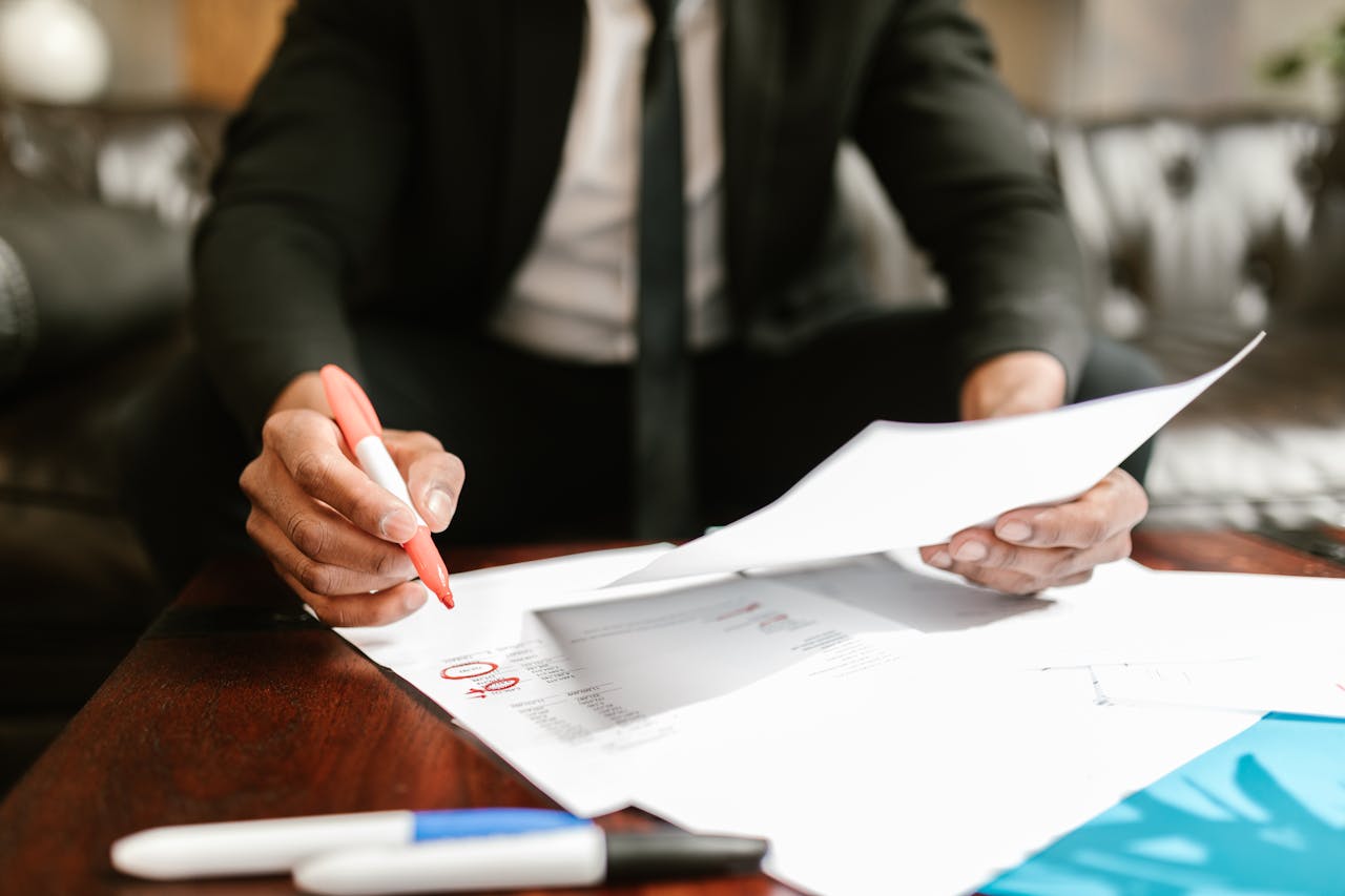 footer-01 Businessman working with financial documents at office desk, highlighting details.